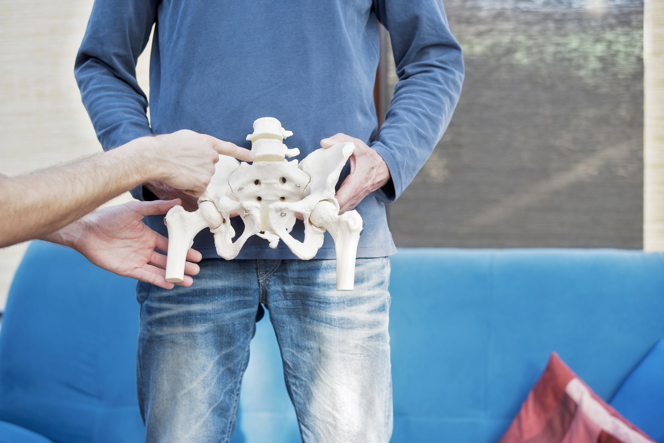 Mann zeigt Hüftskelett